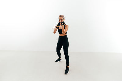 Full length of woman standing against white background