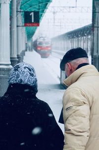 Rear view of people walking in snow during winter