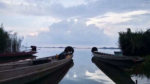 Boats moored on shore against sky