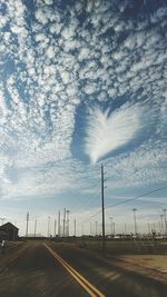 Country road against cloudy sky