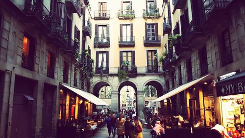 People walking on street amidst buildings in city