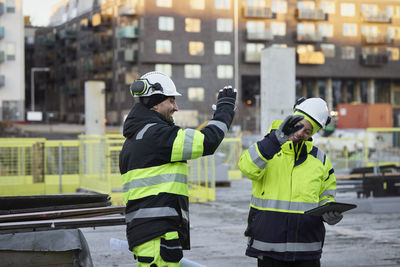 Construction engineers high-fiving at construction site