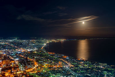 Hakodate city night view, big bright moon golden reflection light up the sea. hokkaido, japan