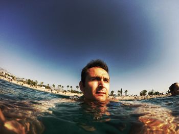 Man looking away while swimming in sea