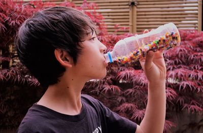 Side view portrait of a boy drinking water