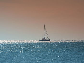 Lone boat in calm blue sea against clear sky