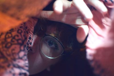 Close-up portrait of young woman hiding