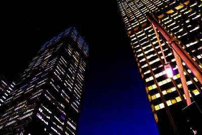 Low angle view of illuminated skyscrapers against sky at night