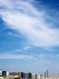 Low angle view of buildings against blue sky during sunny day