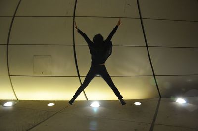 Low angle view of woman dancing against ceiling