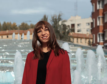 Portrait of smiling young woman standing outdoors