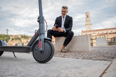 Businessman using mobile phone while sitting outdoors