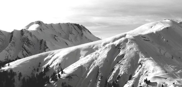 Panoramic view of snow covered mountains against sky