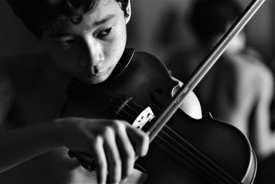 Close up of a boy playing a violin