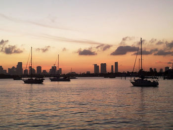 Boats in calm sea at sunset