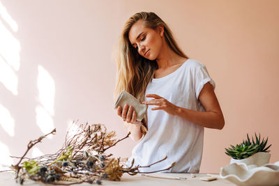 Young woman looking away while sitting on table