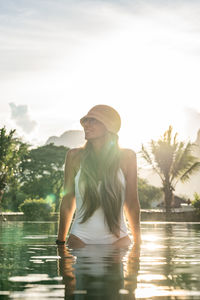 Side view of woman standing against lake