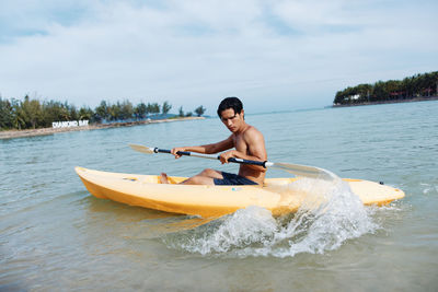 Man surfing in sea against sky