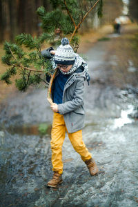 Rear view of boy with umbrella in water