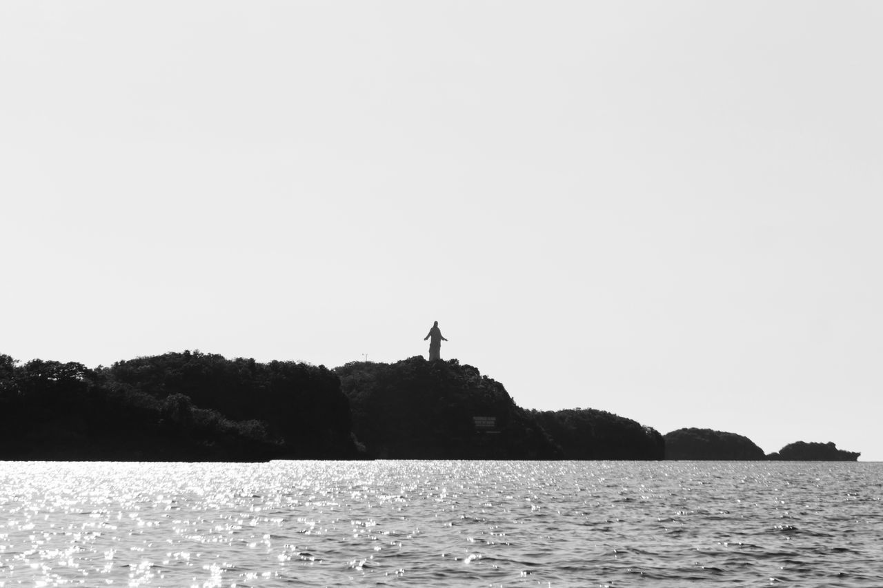 SILHOUETTE MAN OVER SEA AGAINST CLEAR SKY