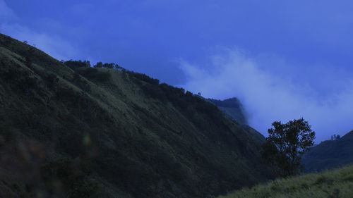 Low angle view of mountain against blue sky