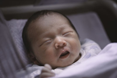 Close-up of baby boy sleeping on bed