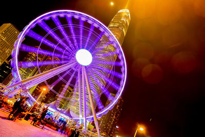 Low angle view of illuminated ferris wheel against sky at night