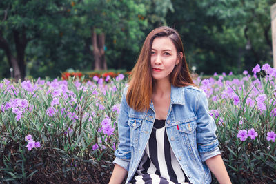 Portrait of a beautiful young woman with purple flower