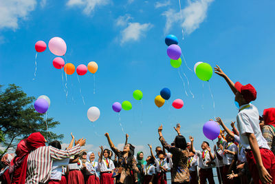 Low angle view of balloons against sky