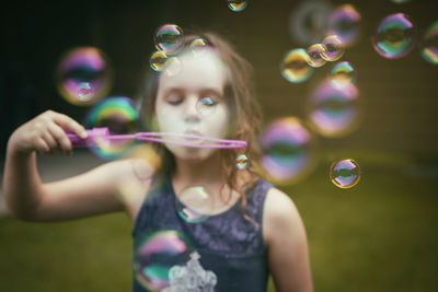 Midsection of woman with bubbles in mid-air