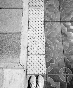 Low section of person standing on tiled floor