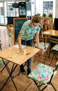 Full length of woman sitting on table in cafe