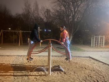 People playing on playground against trees