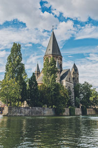 Building by river against sky