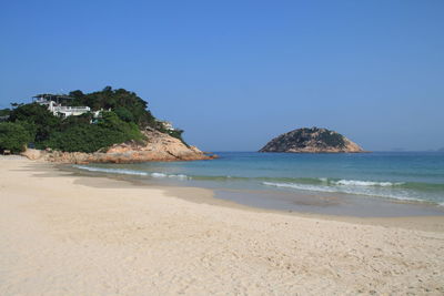 Scenic view of beach against clear blue sky