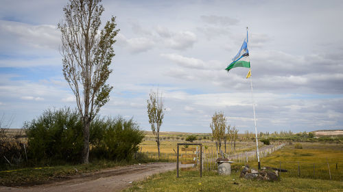 Wind turbines on field against sky