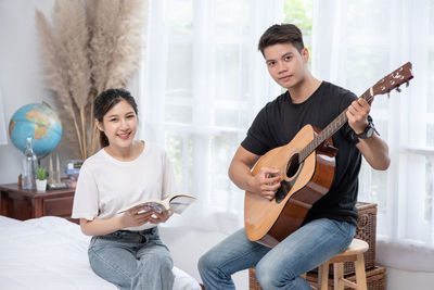 Portrait of smiling man playing guitar