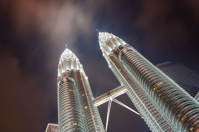 Low angle view of illuminated buildings against sky at night