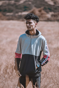 Full length of young man standing on field