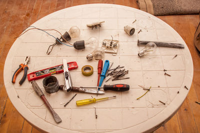 Flat renovation, master of his tools scattered all over the table, pliers, screwdriver, nails, bulbs