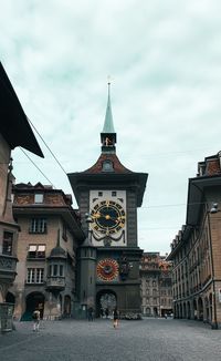 Clock tower amidst buildings in city
