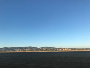 Scenic view of field against clear blue sky