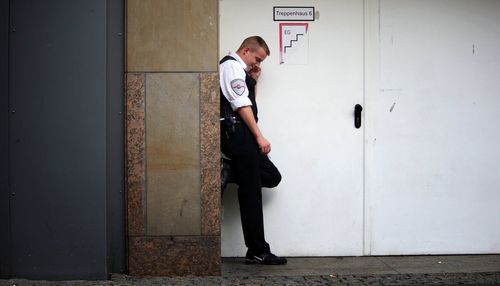 Full length of man standing against door