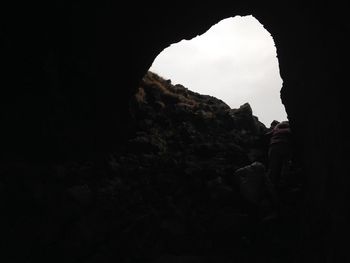 Rock formation against sky seen through cave