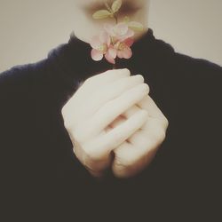 Close-up of hand holding object over white background