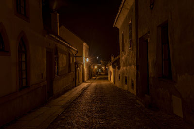 Street amidst buildings at night