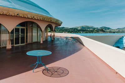 Chairs by swimming pool against sky