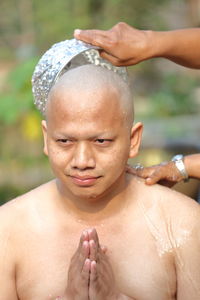 Portrait of shirtless boy with water