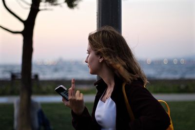 Side view of man holding ice cream outdoors