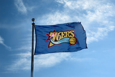 Low angle view of flag against blue sky